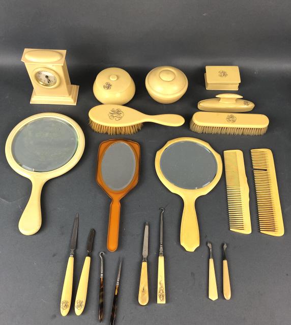 Bakelite, Celluloid, & Ivorine Vanity Pieces: Bakelite, Celluloid, & Ivorine Vanity Pieces ,including 3 mirrors, combs, brushes, clock, etc.Condition, some are monogrammed, spots or loss of silvering on mirrors, comb missing a tooth, clock untest