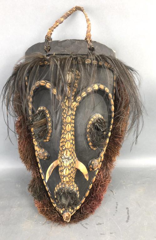 Highly Embellished Wooden African Mask: Highly Embellished Wooden African Mask. Made from wood, shells, bone, feathers, etc. Approx. 21" x 14" Condition, some damage to shells, some scratches , scuffs, chips and cracks, Loose border, handle