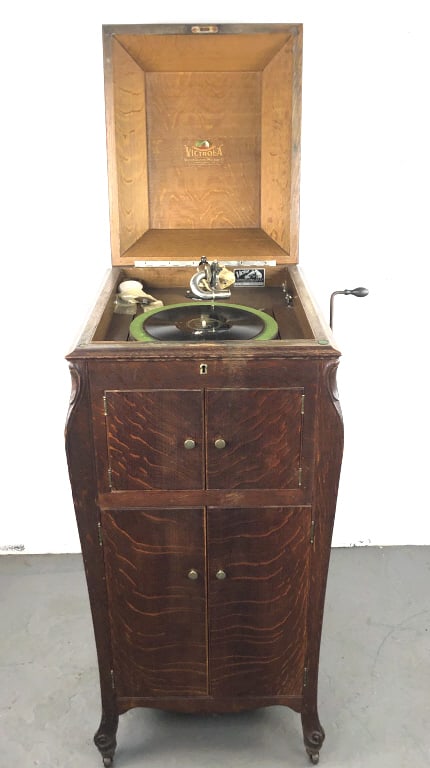 Oak Victor Victrola With Records: Oak Victor Victrola together with records. 45"h x 20"w x 23"d Condition: Working, top needs re-attaching, and scuffs and scratches.