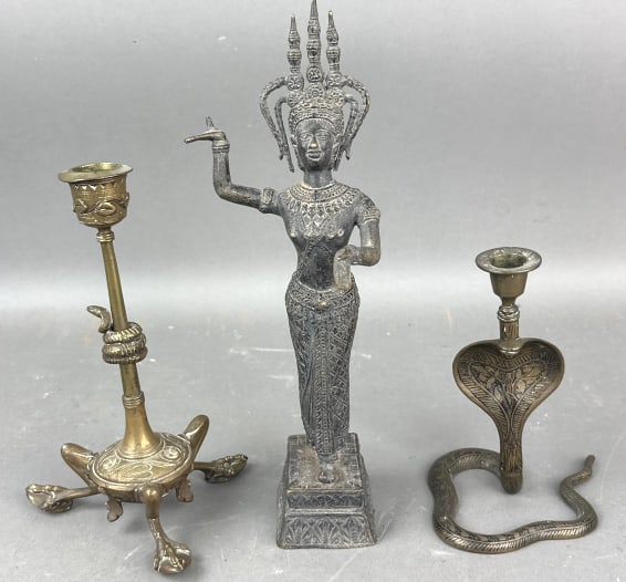 2 Indian Candlestick Holders: 2 Indian Candlestick Holders. Together with brass Hindu Deity. Deity is 12 1/2"h x 4 1/2"w x 4"d. Condition: scratches, scuffs, one bent candlestick t
