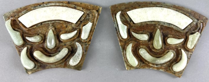 Pair of Haitian Jade Mask Style Beasts: Pair of Haitian Jade Mask Style Beasts. 4 1/4"h x 6 1/2"w. Condition: Broken stone on each piece, some chips to edge.