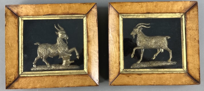 Pair of Framed Bronze Goats: Pair of Framed Bronze Goats. 8"h x 8 3/4"w. Condition: Frames have scratches, scuffs, chipped and cracked veneer.