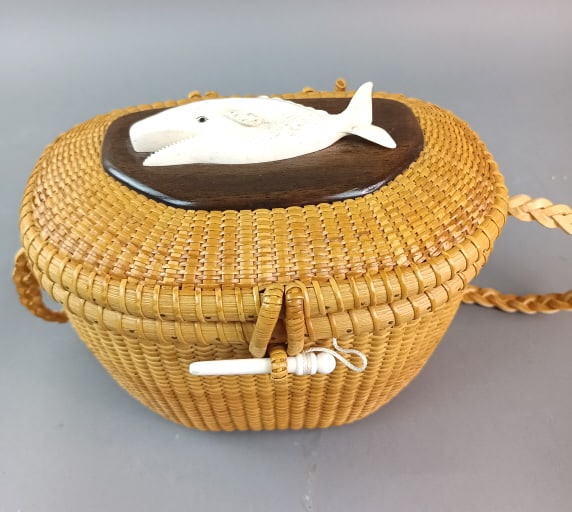 Nantucket Basket with Whale Motif: Nantucket Basket with Whale motif in bone. Signed Susan Chase Ottison. 7 1/2"h x 9"w x 6 1/2"d Condition: One hinge needs repair, some scratches to base.
