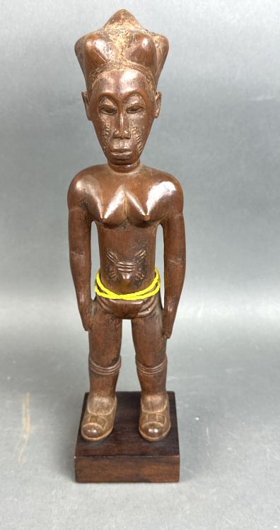 African Baule Attie Carved Wood Figure of Woman: African Baule Attie Carved Wood Standing Figure of Woman. With elaborate coiffure. 12 1/2"h x 3"w x 3"d. Condition: Some cracks and some old clayrepairs.