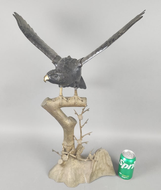 Bronze Eagle on Brass Tree Trunk: Bronze Eagle on Brass Tree Trunk. Eagle has a compartment on its back and removable wings. 26 1/2"h to top of wing x 18 1/2"w from wing tips x 14"d from wing to beak.Condition: Repairs on legs, needs 