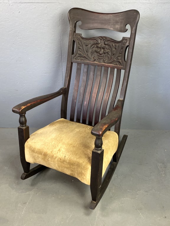 North Wind Face Mahogany Carved Rocking Chair: North Wind Face Mahogany Carved Rocking Chair. 48"h x 27"w x 34"d Condition: Wear to finish, worn & stained fabric.
