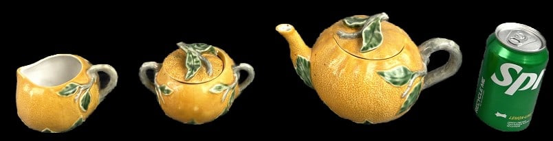 Set of 3 Bordallo Pinheiro Orange Tea Set: Set of 3 Bordallo Pinheiro orange ceramic tea set. Comprised of a teapot, creamer, and sugar bowl. Teapot measures 6"h x 9"dia. Condition: Small chip to glaze on sugar bowl lid.