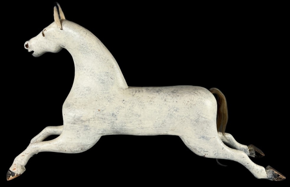 Antique Folk Art Carved Wood Horse: Antique folk art horse. Paint decorated carved wood with glass, leather and hair. Measures 22"h x 40"l x 6.5"w. Condition: Some loss to paint, scratches and chips. Crack to one eye and leg.