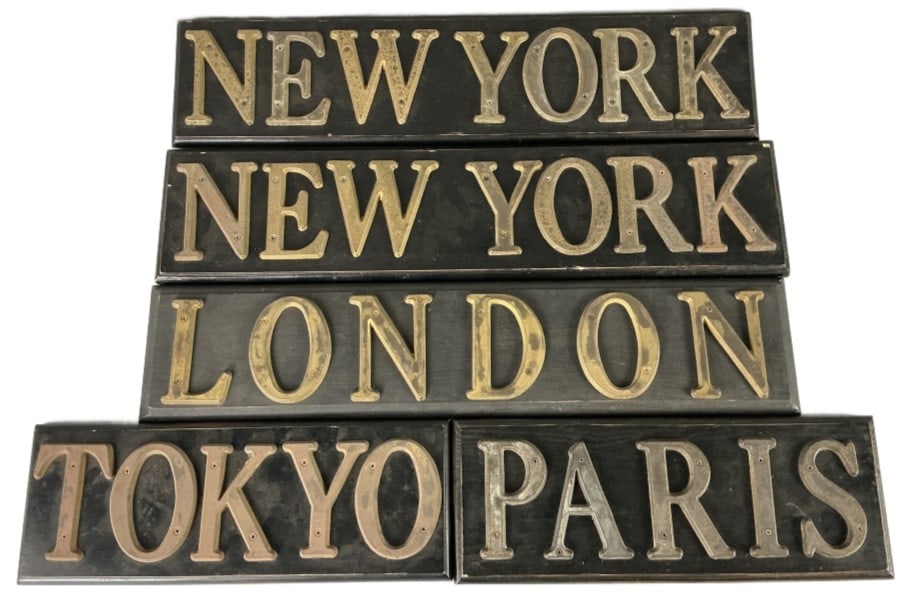 Grouping of New York, London, Paris, Tokyo Signs: Grouping of 5 metal and brass wall signs. Comprised of: 2 New York, 1 London, 1 Paris, and 1Tokyo. Largest measures 5.5"h x 24"l. Condition: Some scratches, nicks to wood, patina.