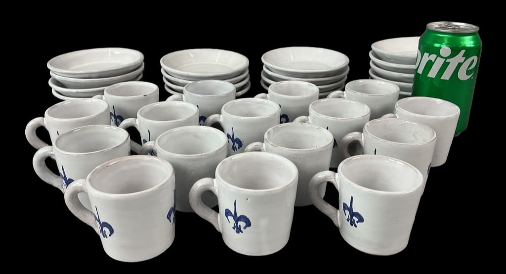 33 Ceramic Fleur de Lis Demitasse Set: Set of 33 pieces faience style ceramic demitasse cups and saucers. Blue and white with fleur de lis motif. Comprised of: 16 cups and 17 saucers. Cups measure 2"h x 2.25"dia. Condition: Some crazing an