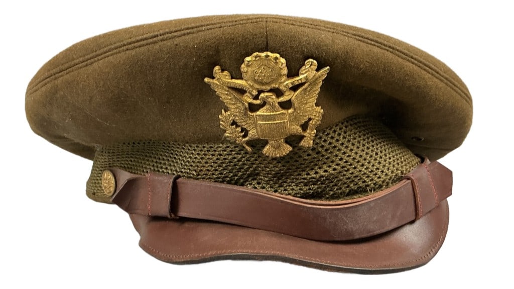 World War II Crusher Officer?s Service Cap: World War II era "crusher" officer’s service cap with a Great Seal cap badge.Wool and leather. Label from Dehners Inc. Measures 7.5"w. Condition: Stains, tear to lining, peeling to leather.