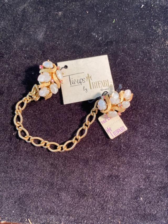 Trifari Tie Ups 1957: Trifari (stamped) bracelet with moon stone and other pink stones. With original 1957 tags. Bracelet measures 7 inches. Tie ups measure 1 inch by 1/2 inch. FREE DOMESTIC SHIPPING.