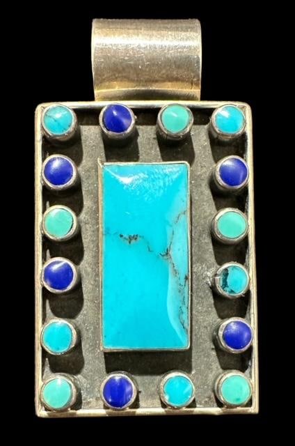 Turquoise and Lapis Native American Sterling Silver Pendant: Native American sterling pendant with turquoise and lapis inlay. Marked .925. Unsigned. Measures 1" x 1.5". Domestic shipping $8.