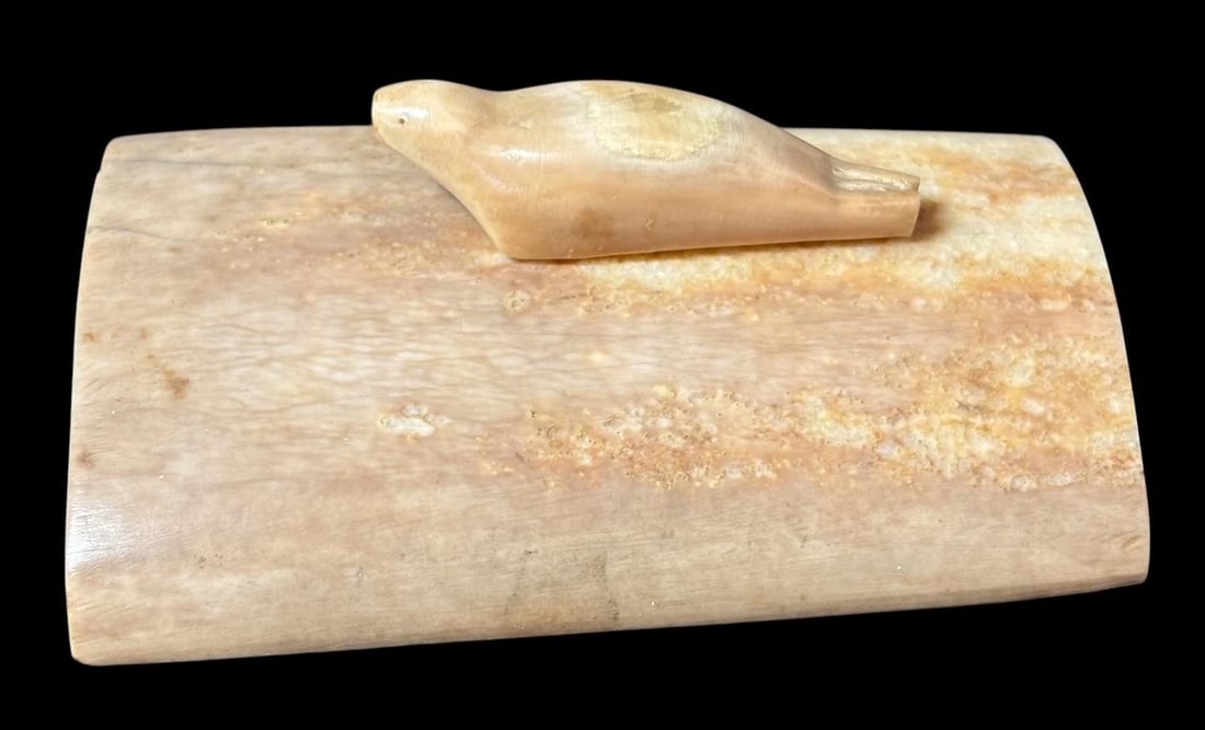 Inuit Carved Walrus Tusk Decorative Paperweight: Inuit carved walrus tusk paperweight with decorative seal carved on top. Measures 3" x 2". Domestic shipping $12