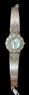 Wrangler Watch with Native American Sterling Reprosse Band: Sterling Wrangler watch band with iridescent watch face. Closed, the watch measures 6.5" circumference. Tested sterling. For in-house shipping, select "bidder arranged." Domestic shipping $8.