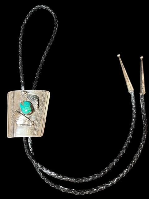 Native American Sterling and Turquoise Bolo Tie: Native American sterling and turquoise bolo tie. Nice hand stamped design around center turquoise stone. Bolo measures 2" x 2". Cord measures 36". For in-house shipping, select "bidder arranged". Dome