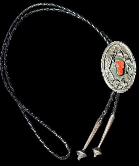 Native American Navajo Sterling and Coral Bolo Tie Signed MH: Native American Navajo sterling and coral bolo tie. Signed MH near vintage Bennett clasp. Sterling tips. Bolo measures 2.5" x 1.5". Cord measures 37". For in-house shipping, select "bidder arranged".