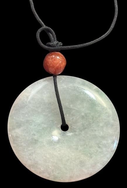 Jade Pendant on Leather Cord: Jade pendant on a leather cord. Pendant measures 2" with a jade bead also above the jade pendant. Cord measures 26".