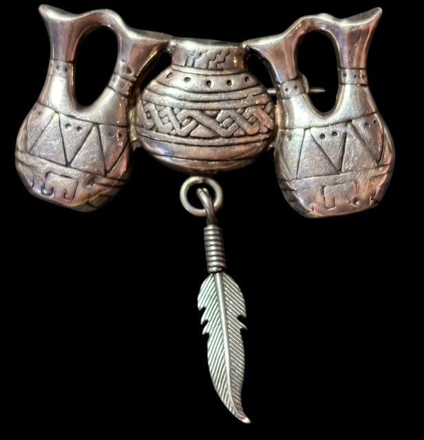 Native American Signed George Sandoval Sterling Brooch: Native American Navajo sterling brooch with an olla, wedding vase and feather design. Marked sterling and signed GS (George Sandoval). Measures 1.75" x 1.75".
