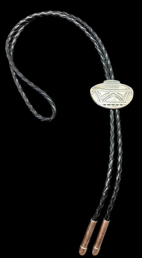 Native American Sterling Bolo Tie Hallmark Signed: Native American sterling bolo tie. Hallmark signed. Bullet shaped silver tips on a 34" cord. Bolo measures 1.75" x 1.25".