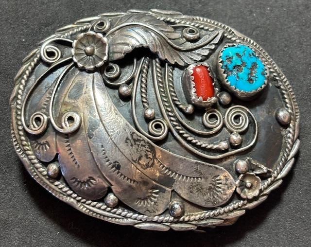 Native American Navajo Signed Sterling Belt Buckle: Native American Navajo sterling (tested) oval shaped belt buckle with coral and turquoise stones. Signed D. Would accommodate a belt up to 1.5". Measures 2.5" x 1.75" and weighs 26 g.