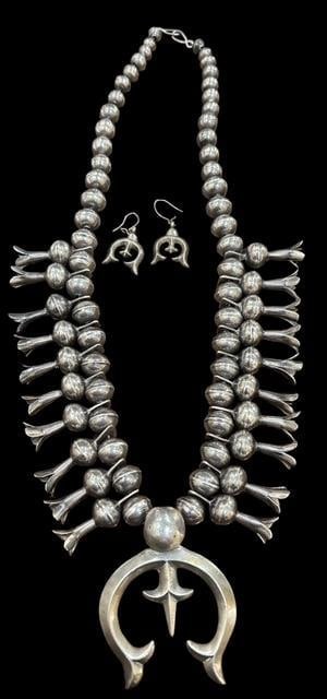Native American Silver Squash Blossom Necklace and Earring Set: Native American silver squash blossom necklace and matching earrings. Necklace includes twenty blooms and a large sandcast Naja. Necklace measures 22" with a 2.75" Naja. Earrings measure 1.5". Total w