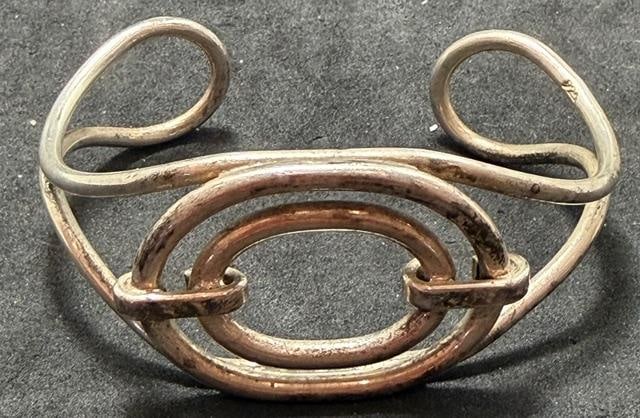 Sterling Cuff Bracelet: Sterling cuff bracelet with wire oval design. Marked .925.Toatl Weight 28 grams. Measures 6.25 with a 1" cuff opening.