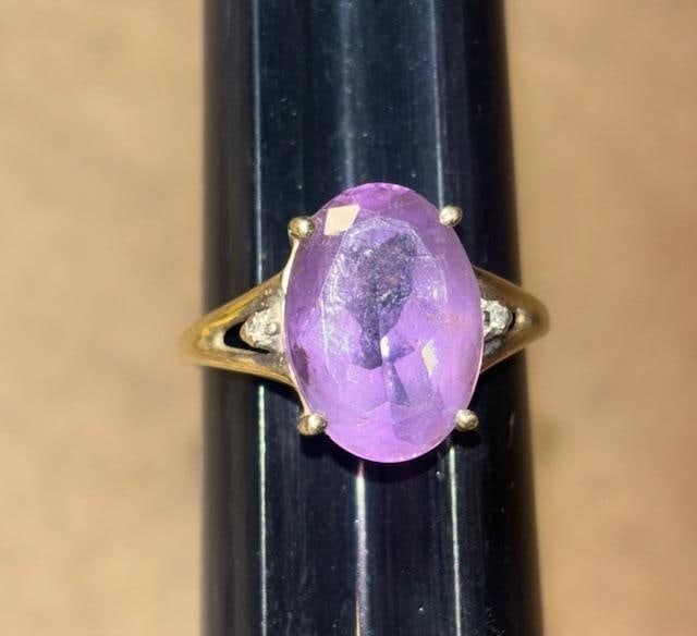 10K Gold Ring with Amethyst Stone: 10k gold ring with center amethyst oval cut center stone with two diamond chips on the side. Total weight 3.7g. Size 8.5.