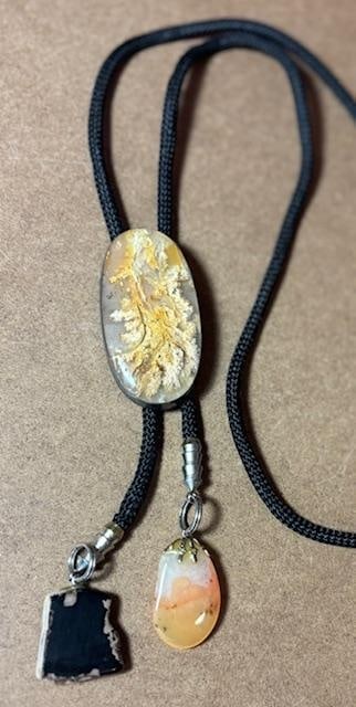 Sterling and Moss Agate Bolo Tie: Sterling and moss agate bolo tie. Stone measures 1" x 2" on a signed sterling frame. Cord measures 38". Polished stone ends.