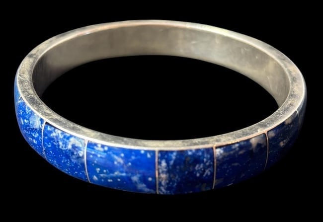 Sterling and Lapis Bangle Bracelet: Sterling (.950) bangle bracelet with inlaid lapis. Measures 3" across.
