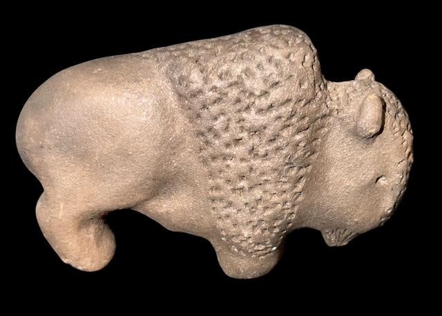 Native American Carved Micaceous Clay Buffalo Figure: Carved micaceous clay buffalo figure. Unsigned. Measures 4" x 2.5" x 1.25".