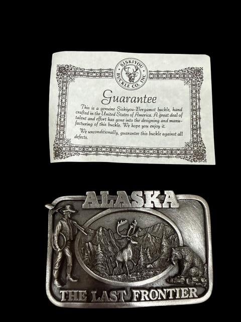 Siskiyou Belt Buckle Alaska the Last Frontier: Siskiyou belt buckle. Alaska the Last Frontier design. Dated 1983. New condition. Measures 3.5" x 2.25".
