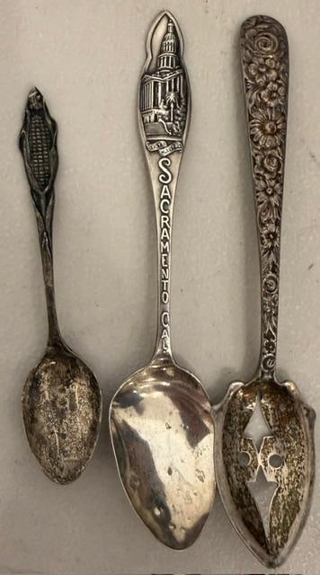 Lot of Three Souvenir Sterling Spoons: Lot of three souvenir sterling spoons. 1) Olive repousse spoon. 2) Sacramento CA. 3) Spoon with corn at the end of the handle. Measures 4" to 5" long. See photos for details.