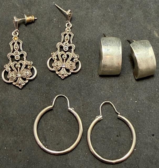 Lot of Three Pairs of Sterling Pierced Earrings: Lot of three sterling pierced earrings. 1) Hoop style. Measures .75" and weighs 1.5g. 2) Crescent shape. Measures .5" x .75" and weighs 10g. 3) Marcasite dangle. Measures .5" x 1.25" and weighs 6g.