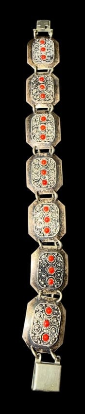 Isralian Sterling and Coral Bracelet: Sterling and red coral bracelet. Marked Jerusalem Israel and sterling. Measures 7" with clasp. Three red stones in each of the seven sections. Total weight 20g.