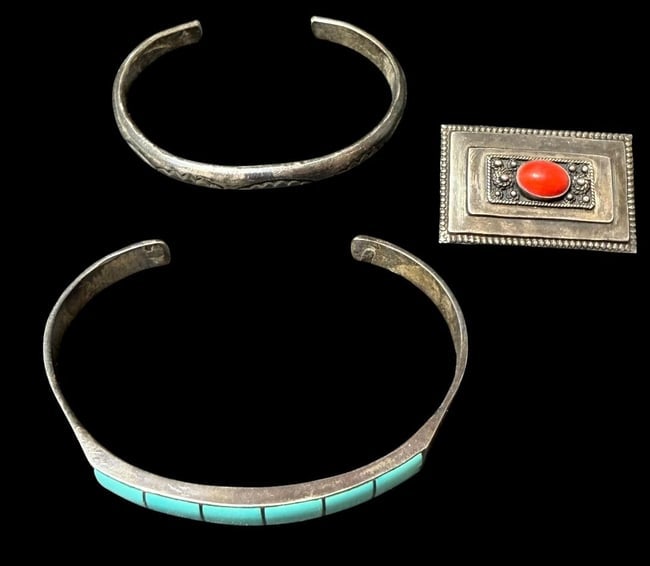 Lot of Three Sterling Jewelry Pieces - Two Cuff Bracelets and One Brooch: Lot of three jewelry pieces. 1) Sterling pin with red center stone. Marked Israel. Measures 1.25" x .75". 2) Tested sterling cuff bracelet with turquoise stones inlaid in six sections. Measures 6" aro