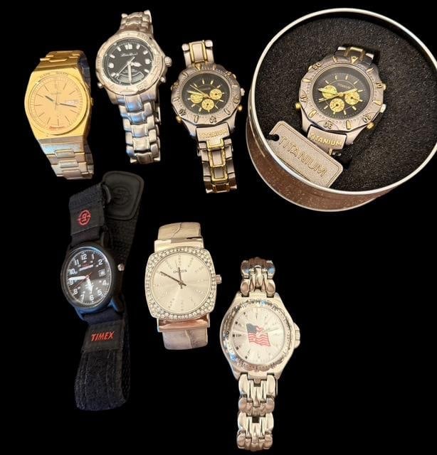 Lot of Seven Assorted Watches: Lot of seven assorted watches. Includes titanium, chronograph, universal, tin, an Eddie Bauer - LGANADIGI # 013, a Chico's lady watch with faux diamond face, non-branded silver tone with a patriotic f