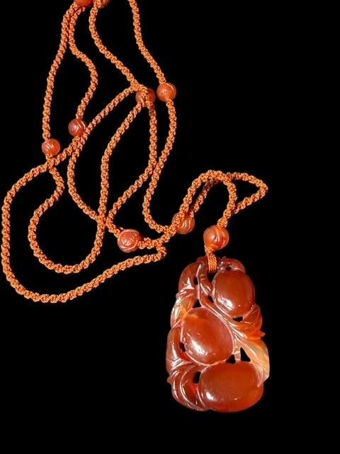 Chinese Carnelian Agate Carved Pendant Necklace: Chinese carnelian agate stone carved fruit pendant on 17" string with carved carnelian beads. Pendant measures 1.25" x 2".