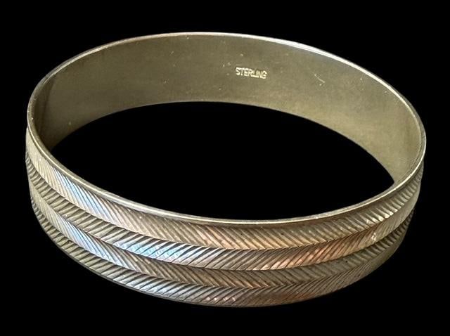 Sterling Bangle Bracelet: Sterling wide bangle bracelet. Marked sterling. Nice hand cut design. Measures 7" around and weighs 39g.