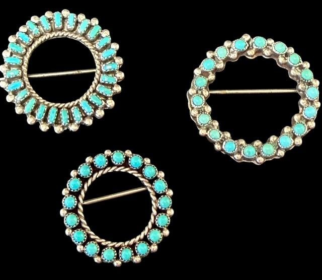 Lot of Three Native American Navajo Sterling and Turquoise Brooches: Lot of three Native American sterling and turquoise brooches. 1) Petit point design. Measures 1" across. 2) Signed TAH. Measures .75" across. 3) Sterling (tested), measures 1" across and weighs 10g.