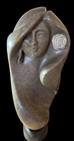 Carved Stone Woman Figure by Jon DeCelles: Carved stone woman figure with flowing hair, signed Jon DeCelles. DeCelles has quarried stone in New Mexico and Utah and works with soapstone, alabaster, marble and granite. Measures 18" tall. Heavy.