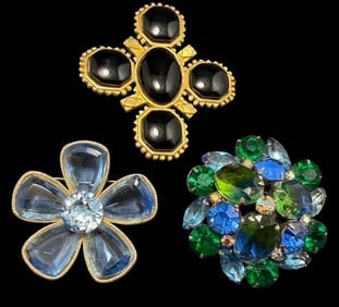 Lot of Three Antique Costume Rhinestone Brooches- Kramer, Capri and Karl Lagerfeld: Lot of three costume jewelry brooches. 1) Signed Kramer. Measures 2" with blueish/green multi stone design. 2) Signed Capri. Measures 2" with pale blue glass floral design. 3) Signed KL (Karl