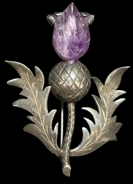 Antique Sterling and Amethyst Scottish Thistle Brooch: Sterling and amethyst Scottish thistle shaped brooch. Marked sterling and hallmark artisan signed. Weighs 14g. Measures 2" x 2.25".