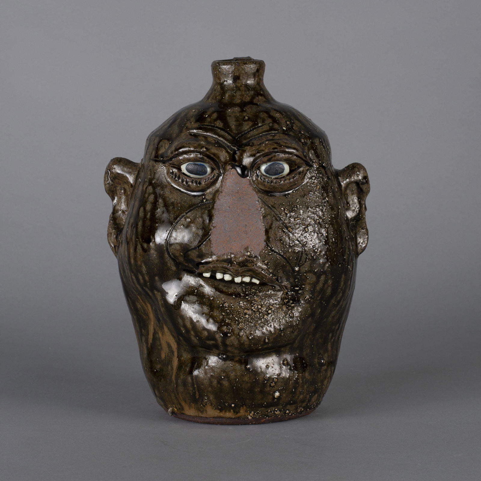 Lanier Meaders face jug nose loss: Lanier Meaders face jug with a kiln disaster nose loss. This happened during the firing. clay eyes clay teeth great drips. No other cracks or problems. 11"