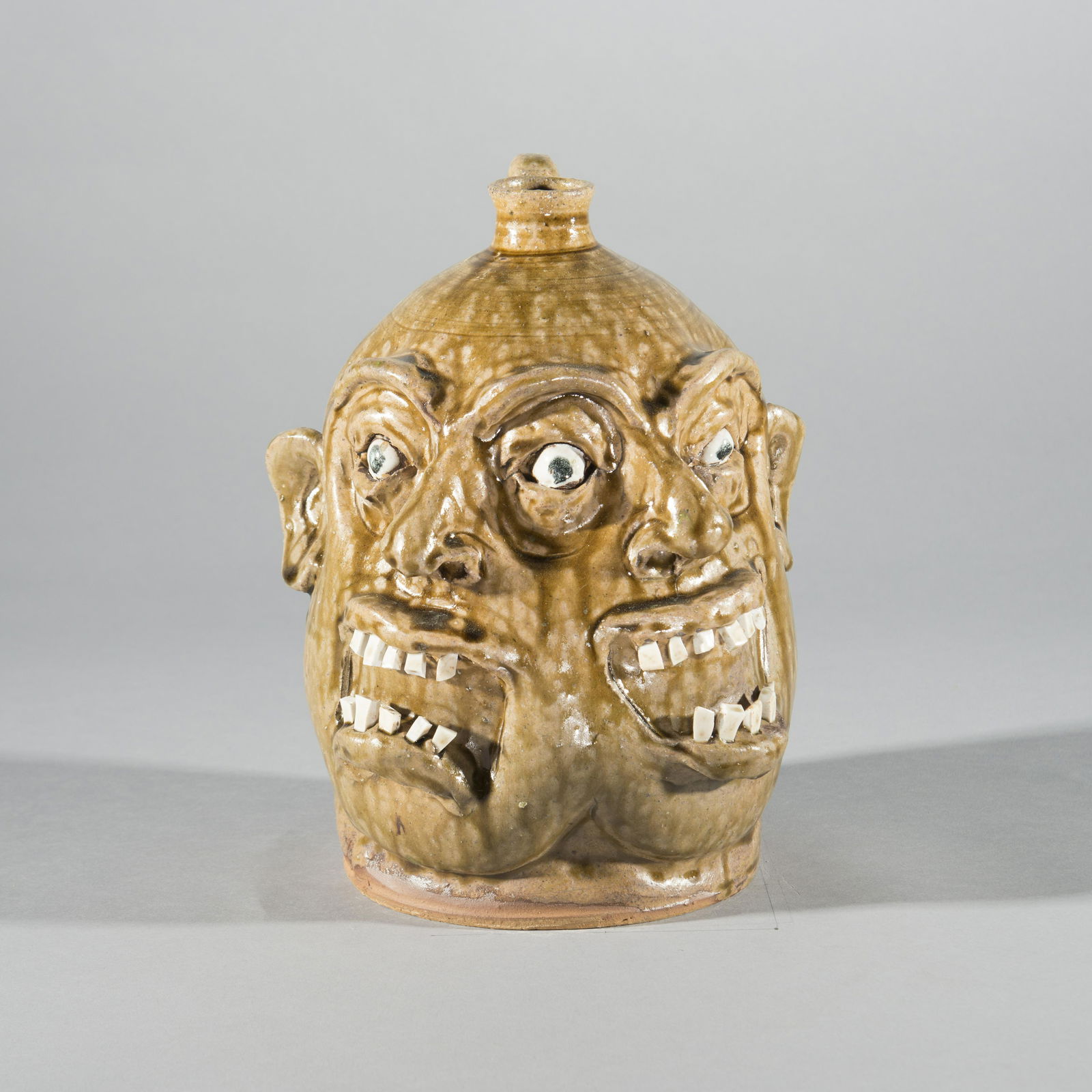 Marvin Bailey Double Face Jug: Marvin Bailey (born 1960) Lancastar, SC. A folk art double mouth, doble nose 3 eye face jug by South Carolina potter Marvin Bailey. Each mouth has a double row of china plate teeth. Ht 10"