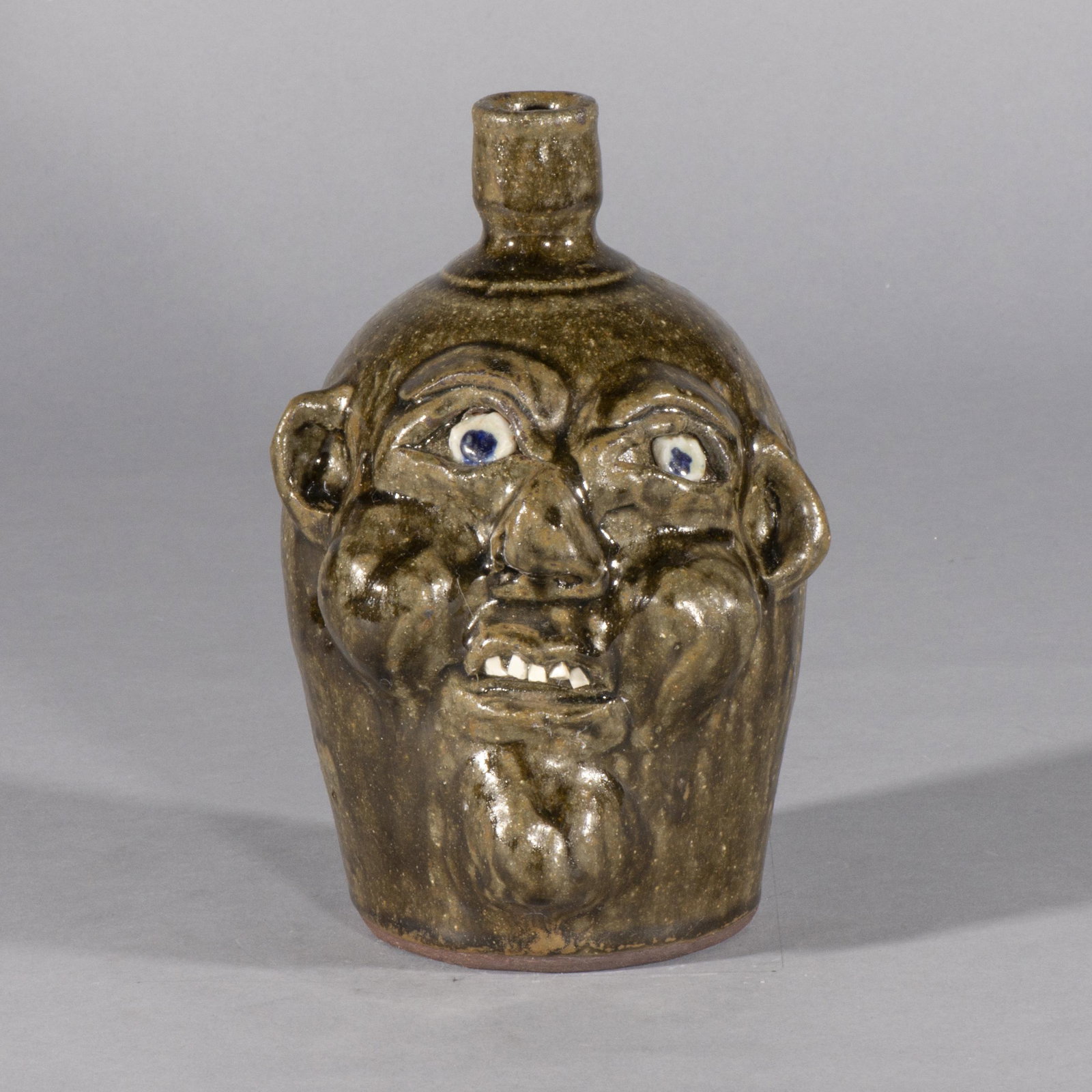 Harold Hewell Face Jug: rare signed Harold Hewell and Grace Nell Hewell dated 2-5-99 fat protruding cheeks and chin with a single row of china teeth. Height is 8"