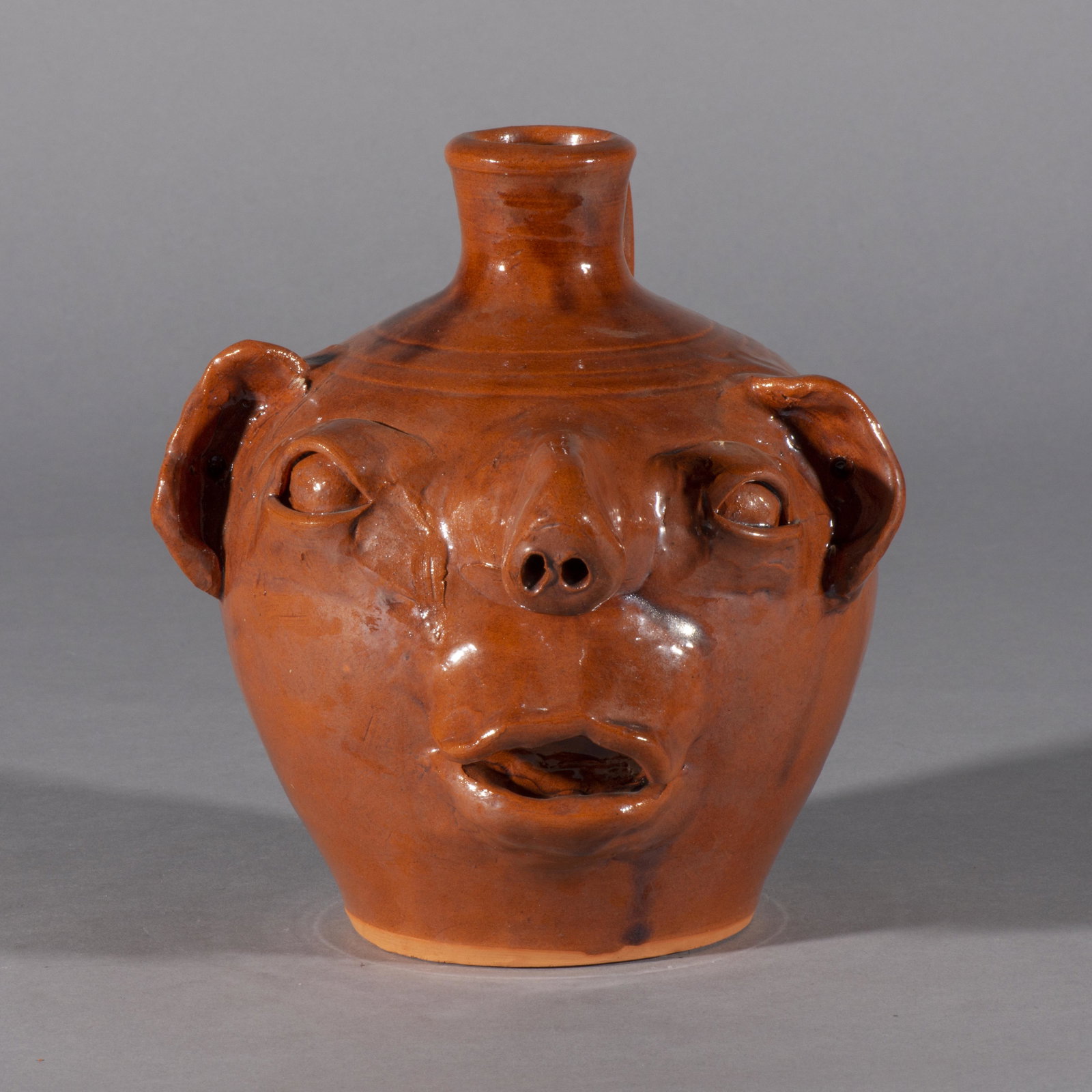Rare ML Owens Face Jug Long nose: a very unique ML Owens face jug with a long nose the nose is 2" long. 7.5" tall. This is a rare and odd form of a face jug open mouth with no teeth signed ML Owens on the bottom and dated 1986