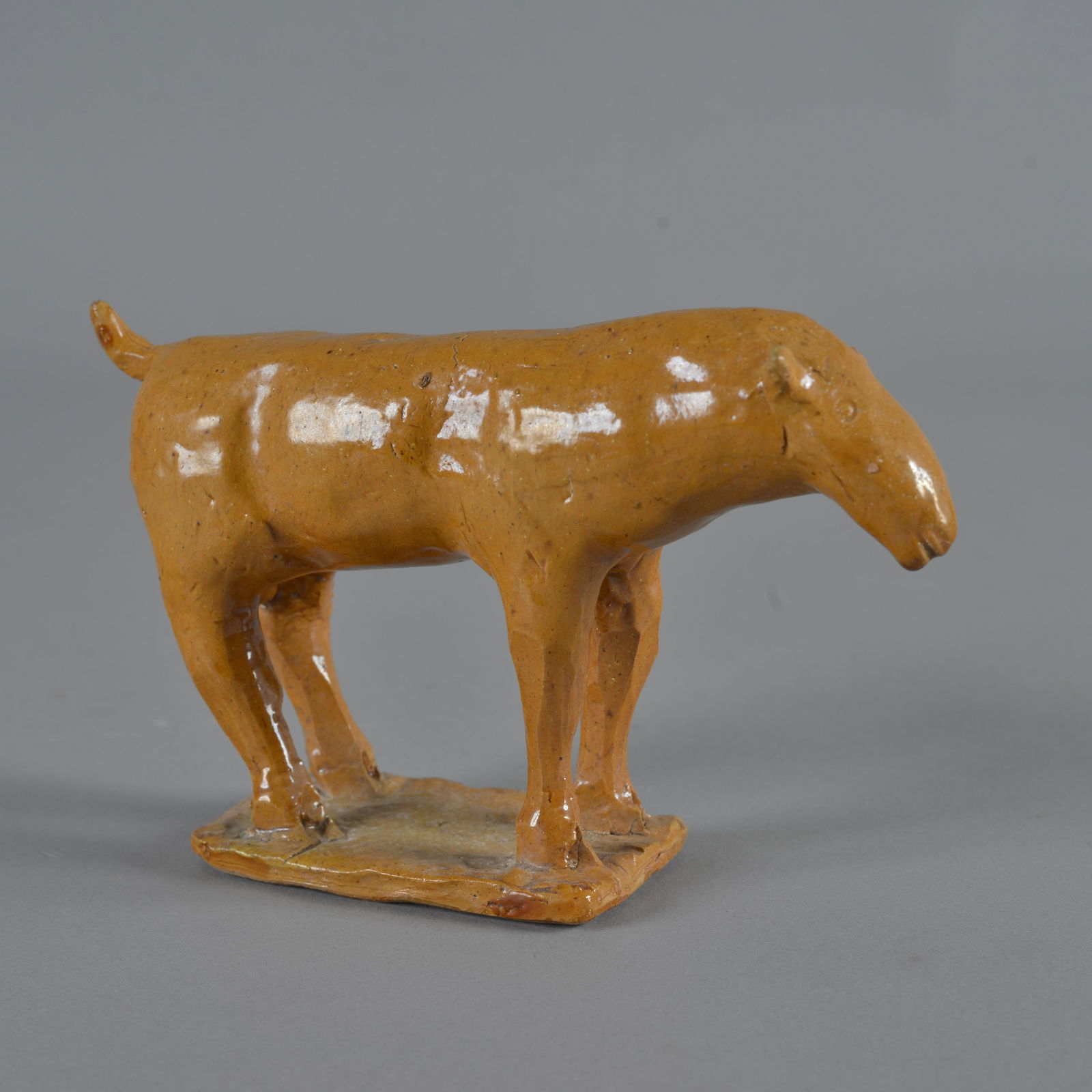 Charles Moore Cow (orange): in the jugtown orange glaze. Signed on bottom Charles Moore no date. Height 5", length 8"
