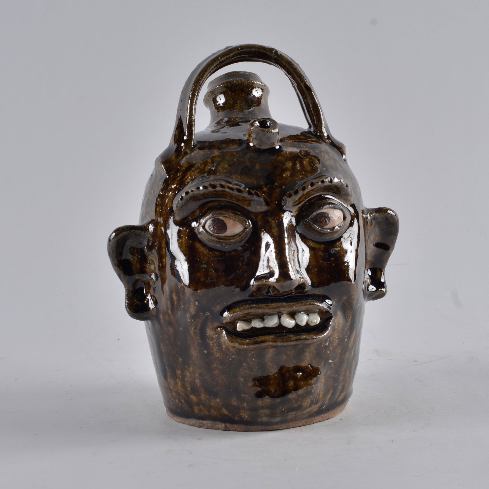 Clint Alderman Monkey Face Jug: signed and dated 2020 Clint Alderman. Clay teeth. Harvest jug/monkey jug style with the bell handle. Height 8.5"