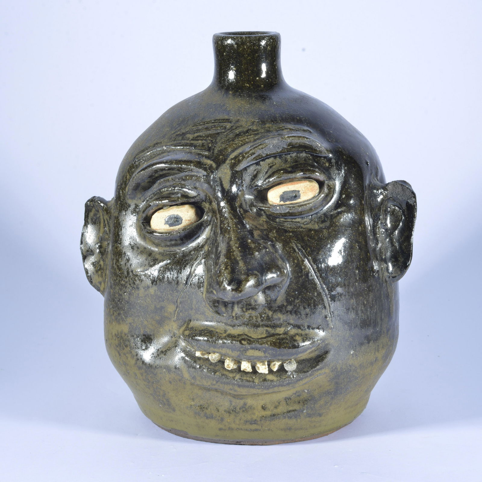 Lanier Meaders Rock Tooth face jug: rock tooth, clay eyes, wire cut on bottom, shallow glaze shallow chip to top of right ear and glaze chip top of right eyebrow, intentional incise cheek & forehead decoration - 9"